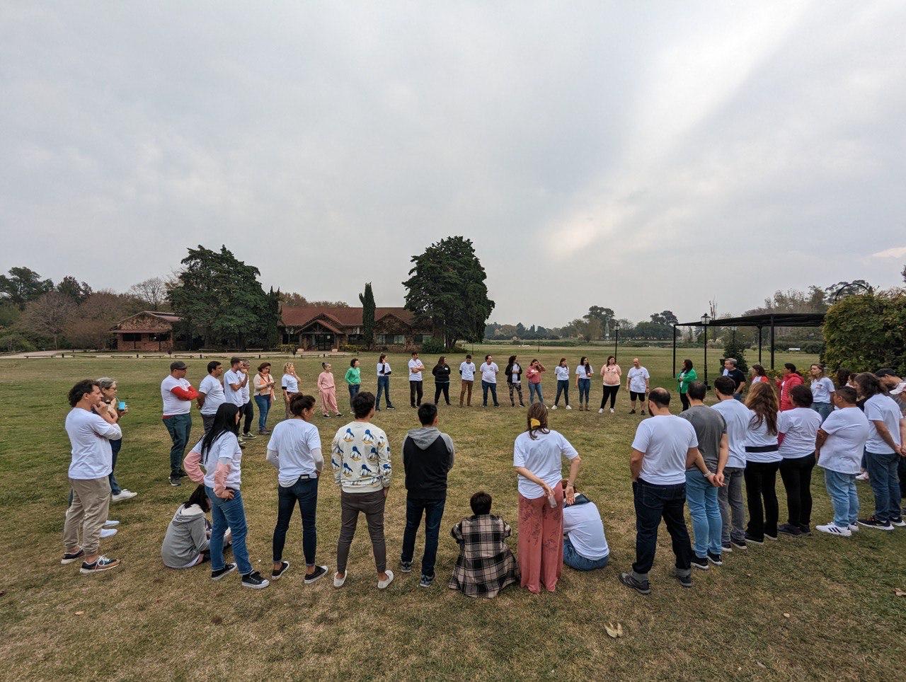 Equipo reunido en ronda durante una experiencia de team building al aire libre